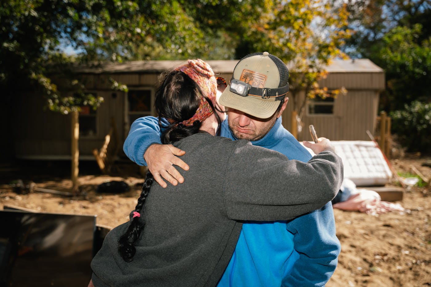 Cassandra Phillips hugs a fellow Swannanoa resident while checking on a neighbor whose home was severely damaged in this town 10 miles east of Asheville. Normally about two feet deep, the Swannanoa River swelled to around 27 feet during Helene.