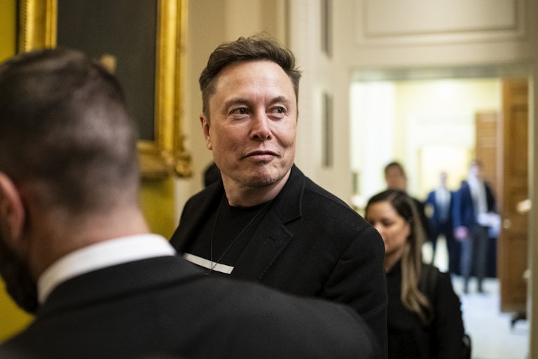 Elon Musk looks up while walking in the Capitol