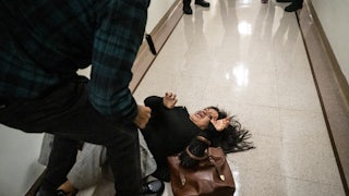 A woman screams on the ground after she is tackled by an ICE agent.