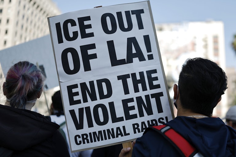 A person holds up a sign that says, "ICE out of LA! End the violent criminal raids!" during a protest against ICE in Los Angeles
