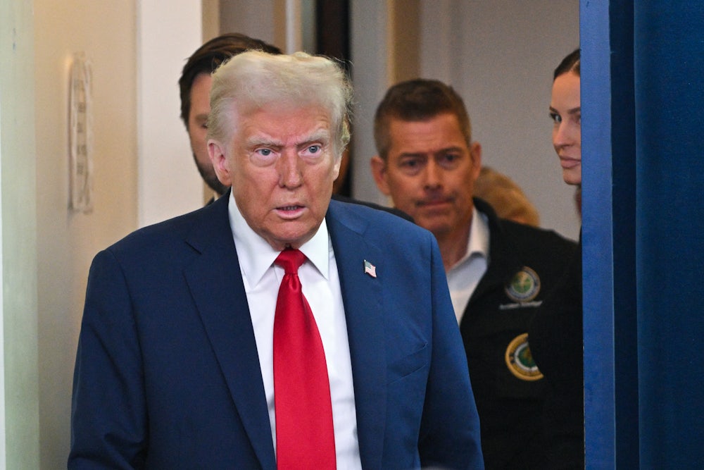 Donald Trump is trailed by Transportation Secretary Sean Duffy at a press conference in late January.