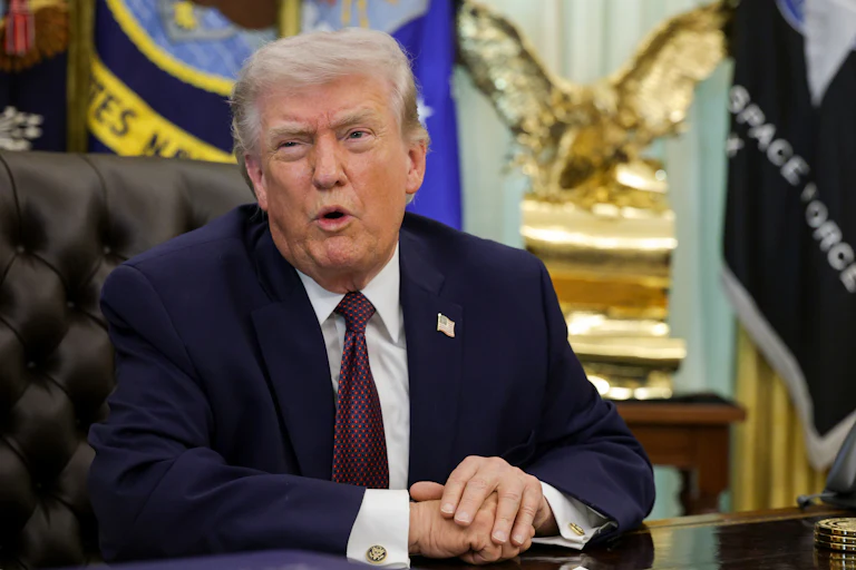 President Donald Trump speaking at his desk in the Oval Office of the White House.