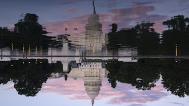 The U.S. Capitol Building is reflected in the Capitol Reflecting Pool at sunset.