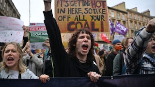Youth activists shout with raised fists.