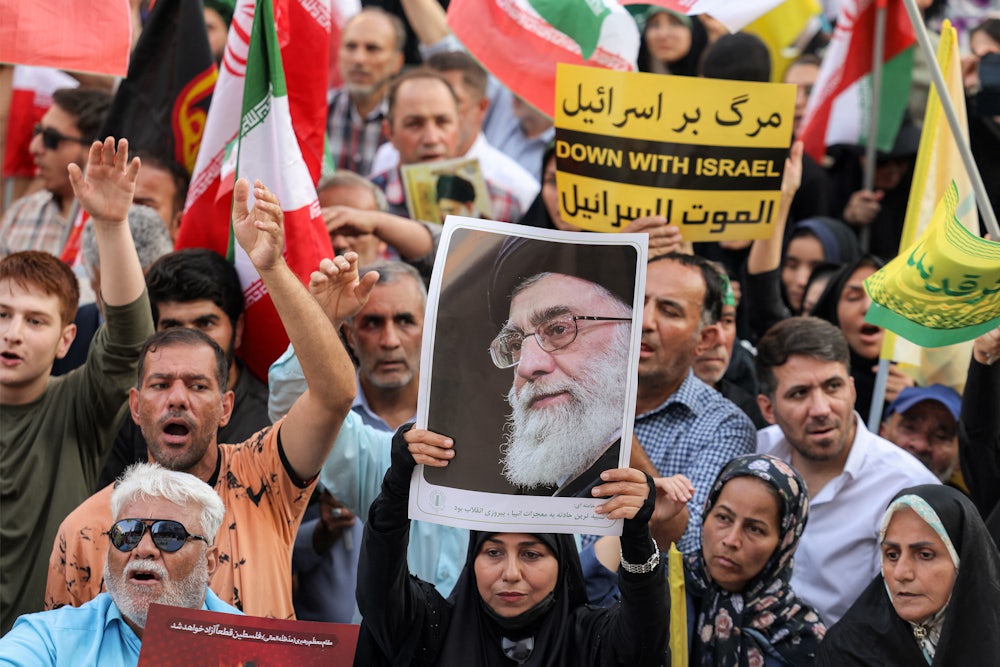 A demonstrator holds a picture of Iran’s Supreme Leader Ayatollah Ali Khamenei