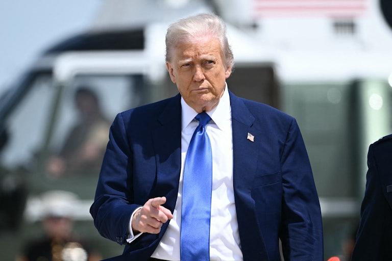 Donald Trump points while walking on an airport tarmac