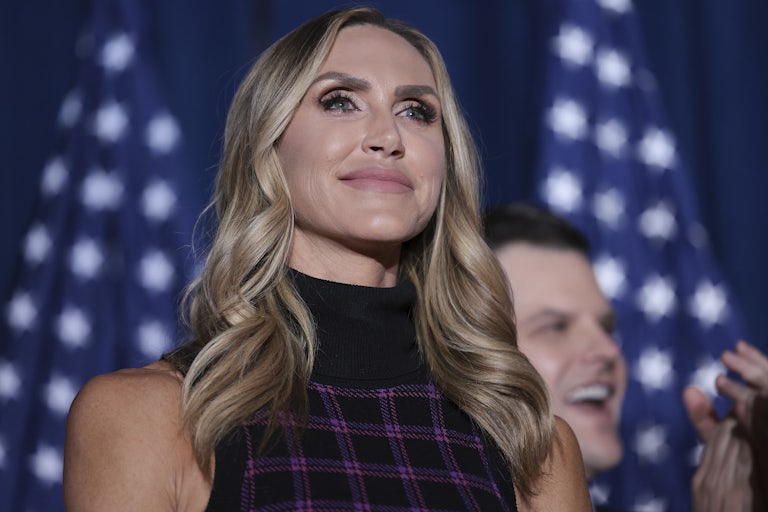 Lara Trump stands in front of two American flags