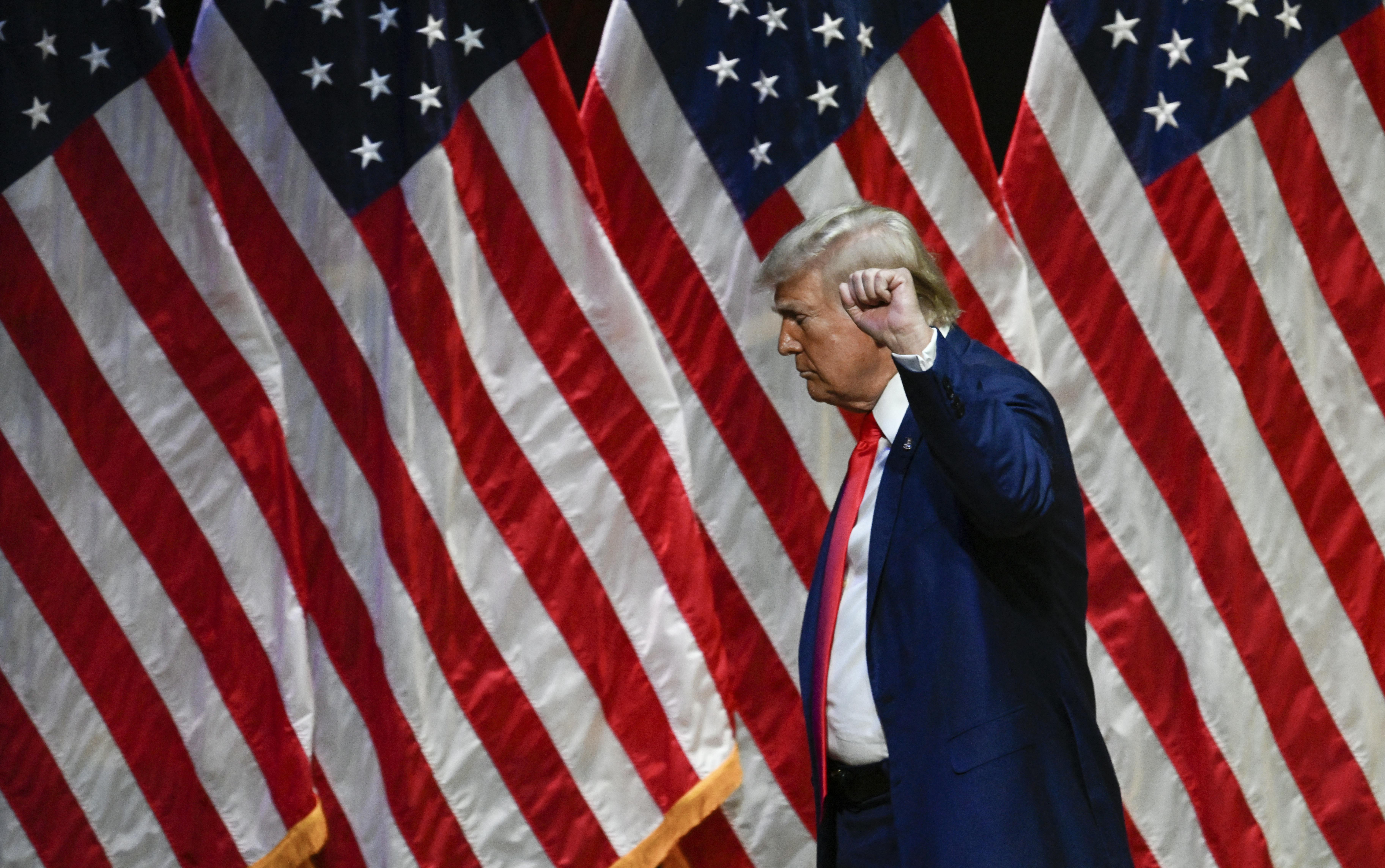 Donald Trump raises his fist as he leaves after speaking during a campaign rally in North Carolina.