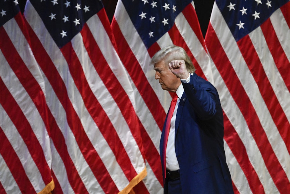 Donald Trump raises his fist as he leaves after speaking during a campaign rally in North Carolina.