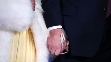 Close-up of Nicki Minaj and Donald Trump holding hands, with Nicki’s long nails and the concealer on Trump’s hand