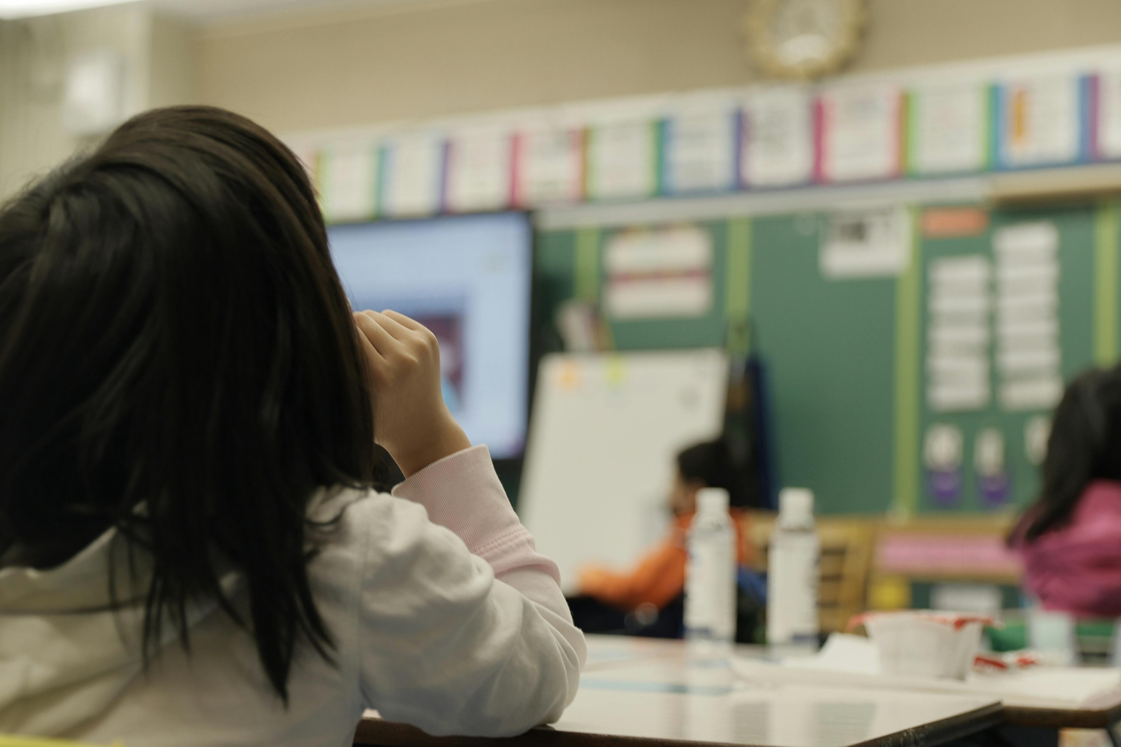 A masked student sits in class.