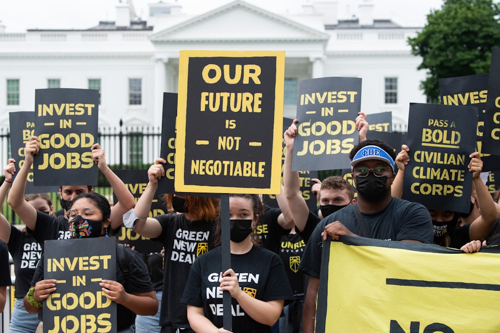 Climate activists hold signs in front of the White House.