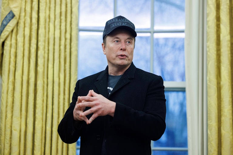 Elon Musk gestures while speaking during a press conference in the Oval Office