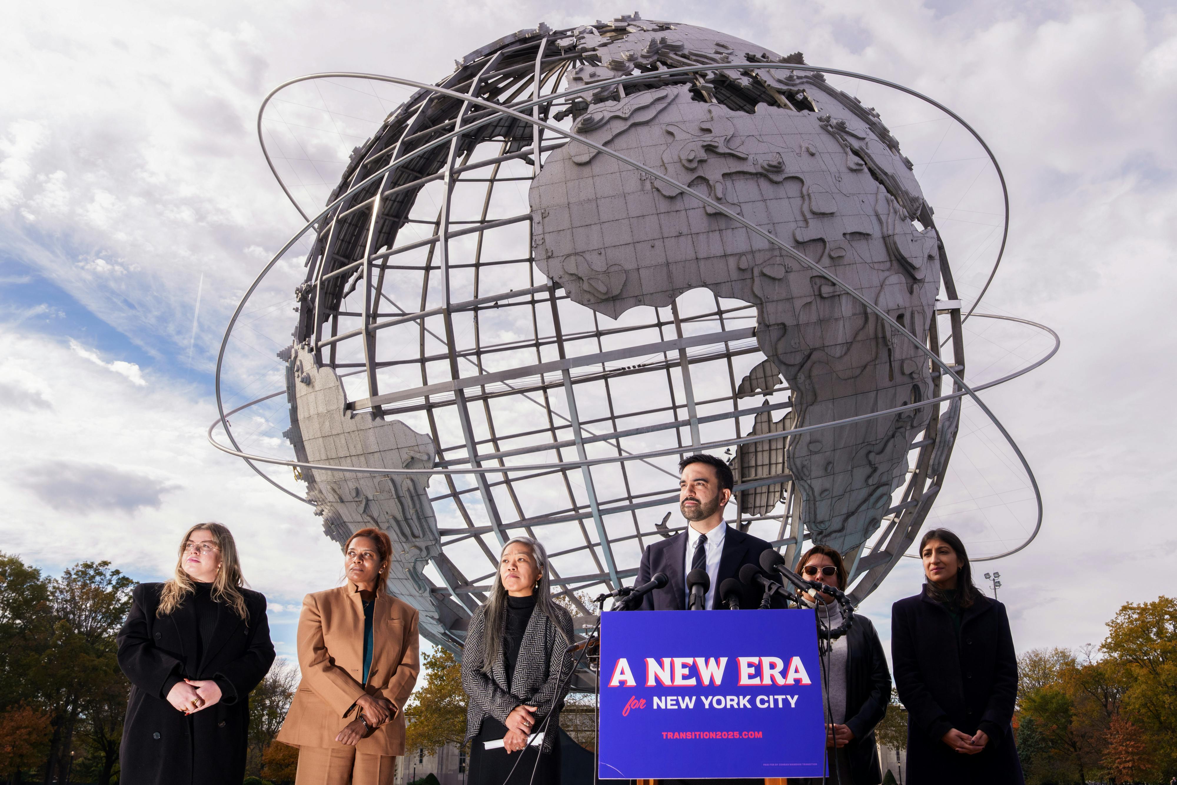 Zohran Mamdani speaks to reporters alongside his transition team, from left, Elana Leopold, Melanie Hartzog,Maria Torres-Springer, Grace Bonilla, and Lina Khan, at Flushing Meadows Corona Park.