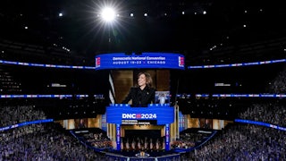 This zoomed-out shot shows the convention all with thousands of attendees, Kamala Harris on stage, and video of her projected above.