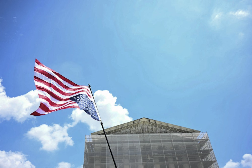 People hold an upside down American flag outside the Supreme Court.