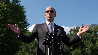 Stephen Miller speaking at a microphone