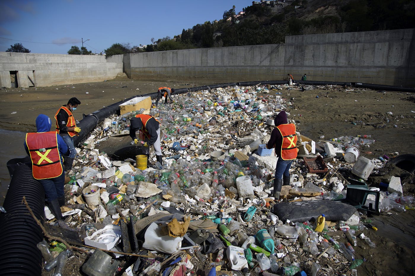 A photo a trash boom in Los Laureles Canyon. When it rains, the boom floats up with the floodwaters, skimming off piles of plastic bags, milk bottles, and Styrofoam.