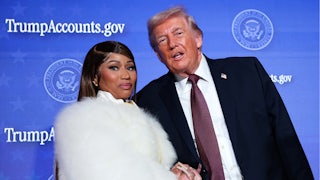 Donald Trump speaks to Nicki Minaj as they stand next to each other holding hands