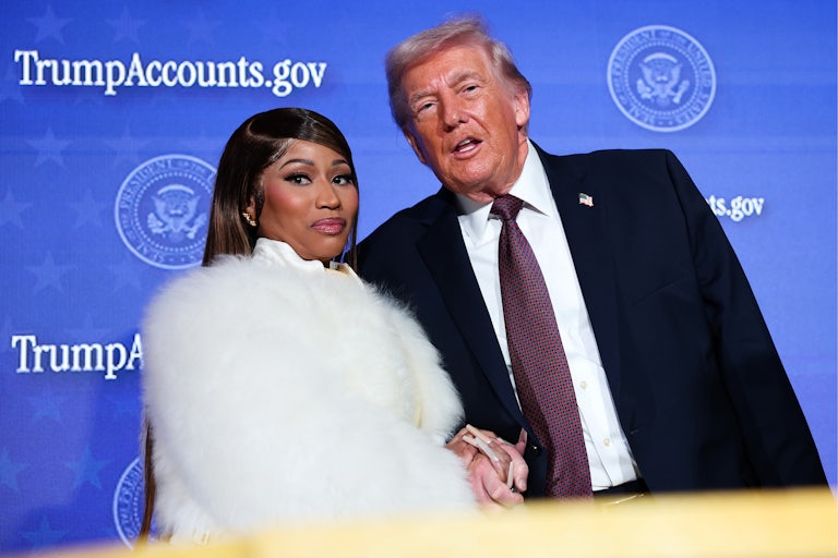 Donald Trump speaks to Nicki Minaj as they stand next to each other holding hands