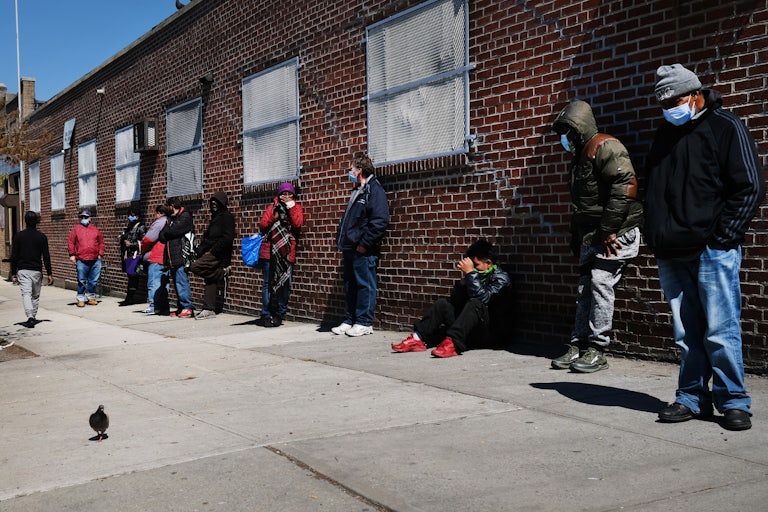  People wait in line to receive food at a food bank in the Brooklyn borough of New York City.