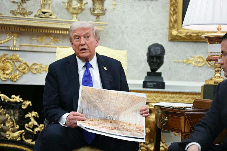Trump holds up a picture of his ballroom