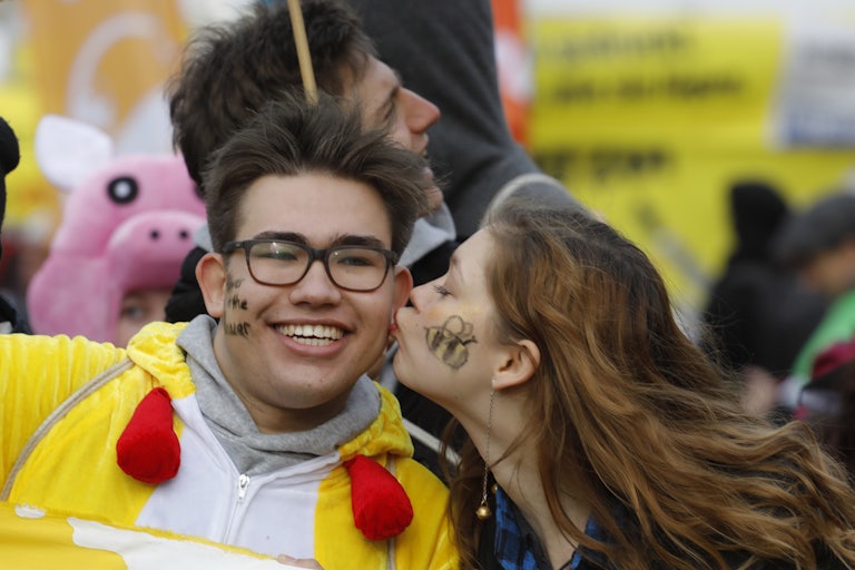 A protester kisses a fellow protester on the cheek.