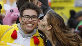 A protester kisses a fellow protester on the cheek.