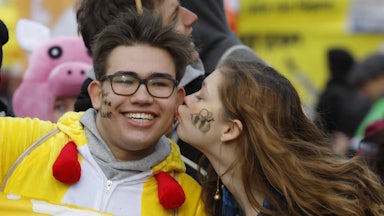 A protester kisses a fellow protester on the cheek.
