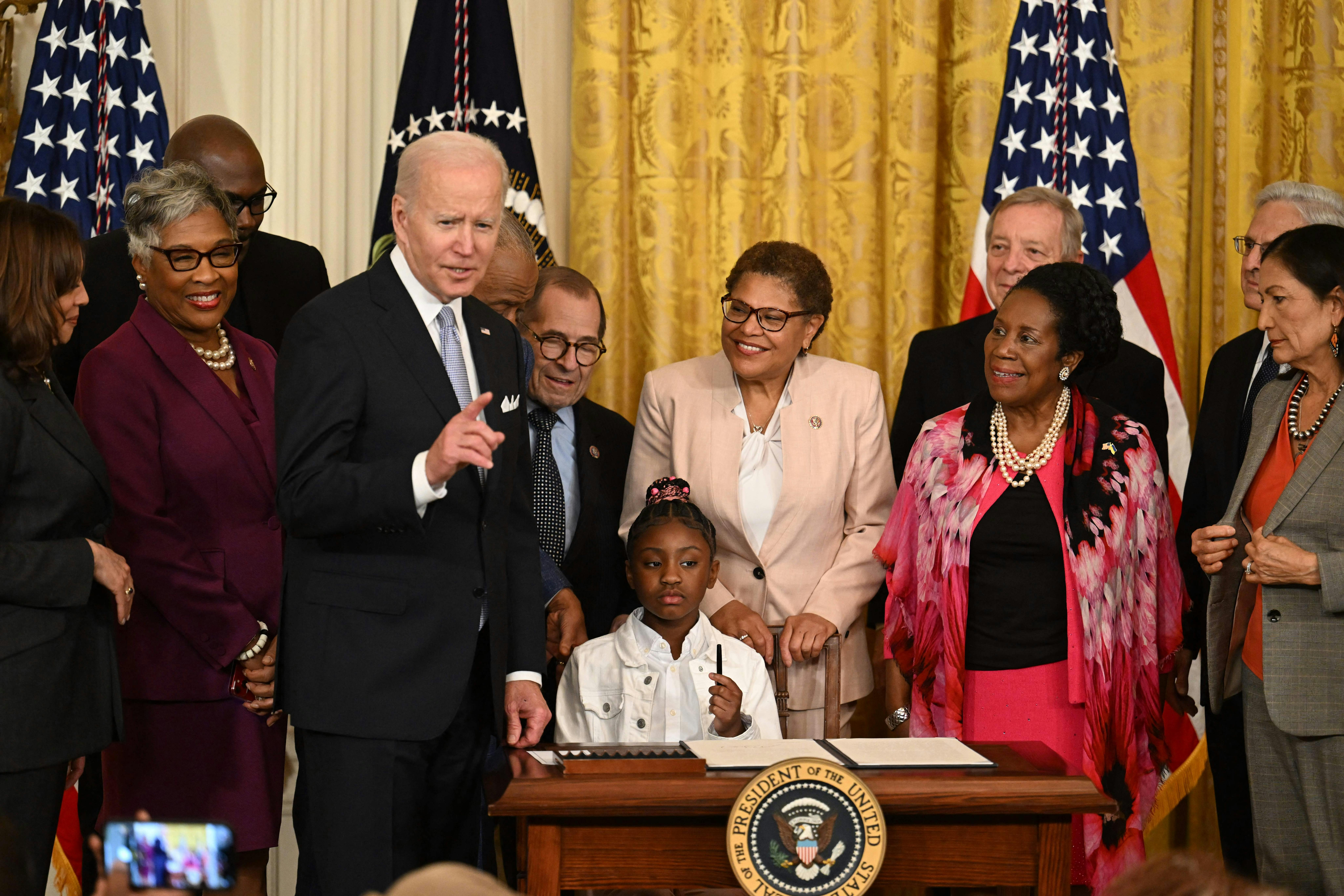 Gianna Floyd, daughter of George Floyd, holds a pen during a signing ceremony at the White House