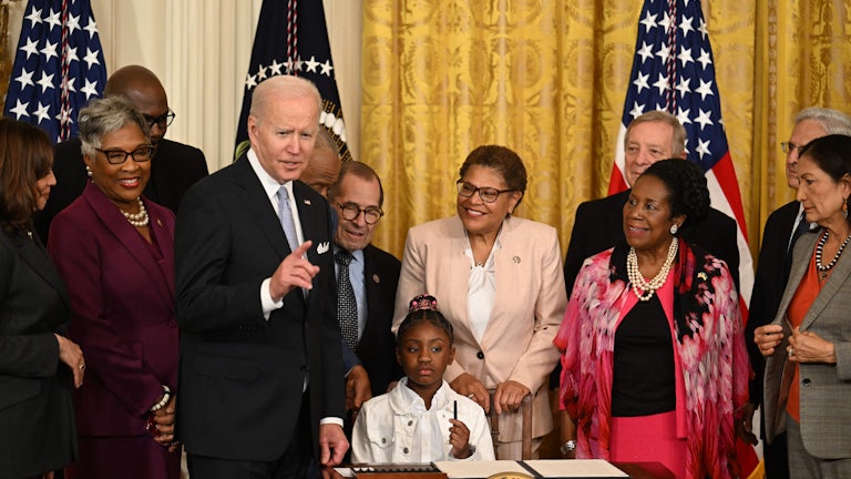Gianna Floyd, daughter of George Floyd, holds a pen during a signing ceremony at the White House