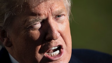 Donald Trump scowls as he speaks to reporters.