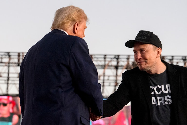 Elon Musk and Donald Trump shake hands at the latter’s campaign rally