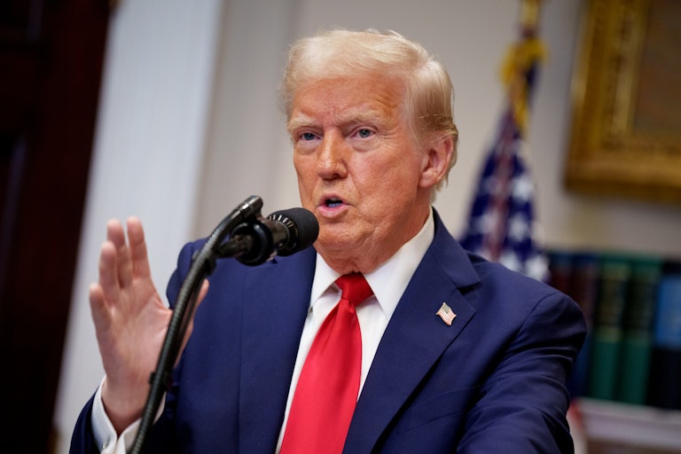 Donald Trump gestures while speaking at a podium