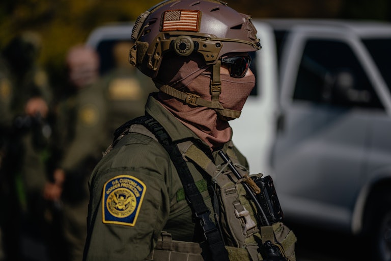 A masked federal immigration officer