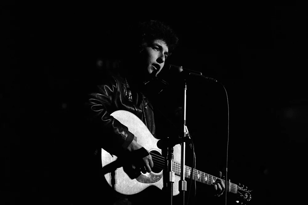 Bob Dylan plays acoustic guitar