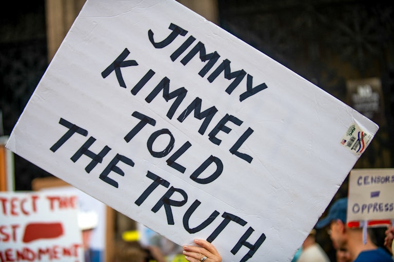 A protest sign says, "Jimmy Kimmel told the truth"