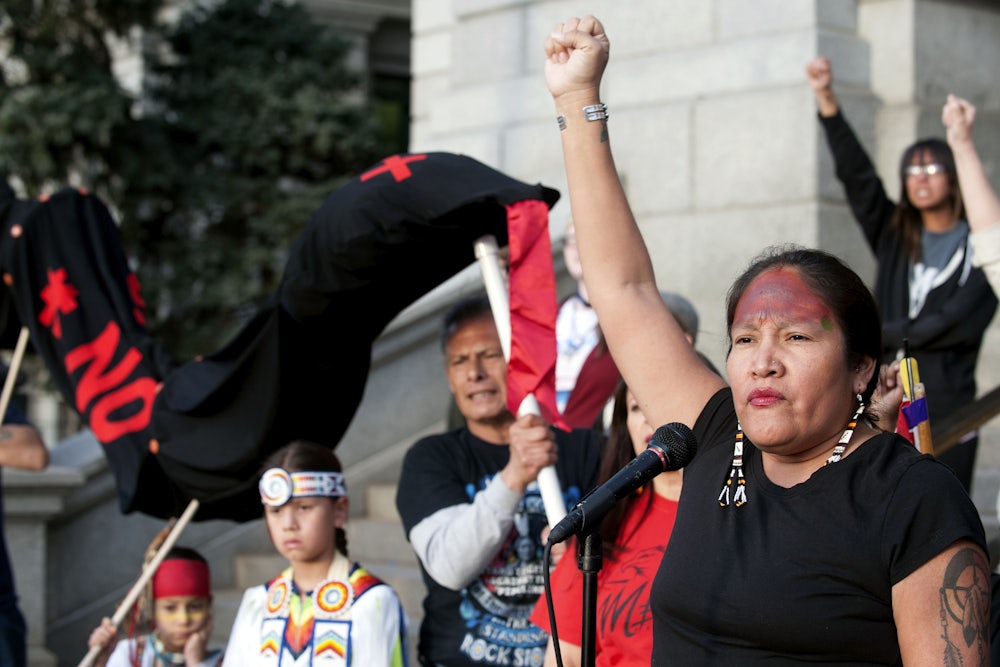 A woman stands with her first raised.