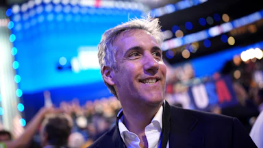 Michael Cohen smiles while walking at the 2024 Democratic National Convention