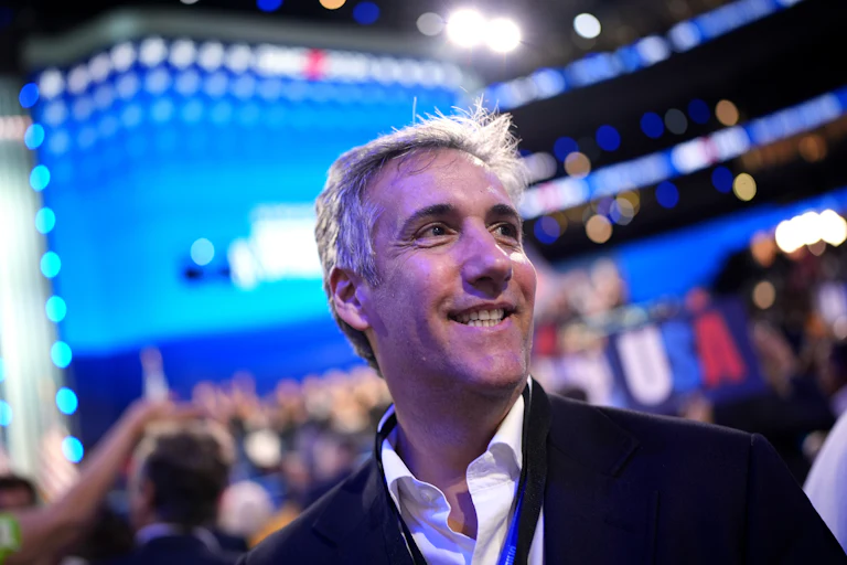 Michael Cohen smiles while walking at the 2024 Democratic National Convention