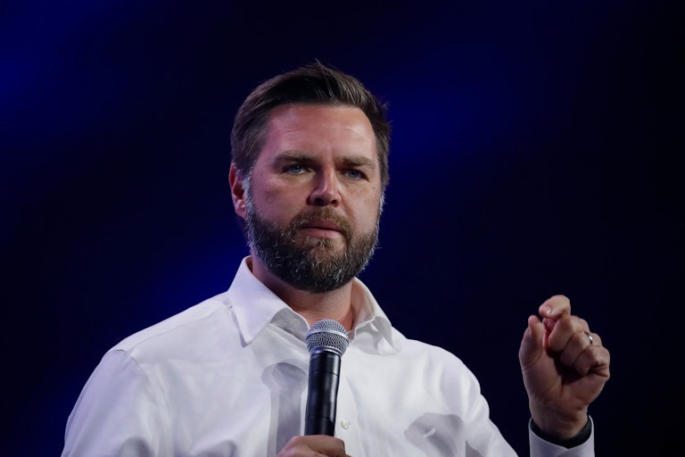 J.D. Vance speaks on a mic and makes a hand gesture