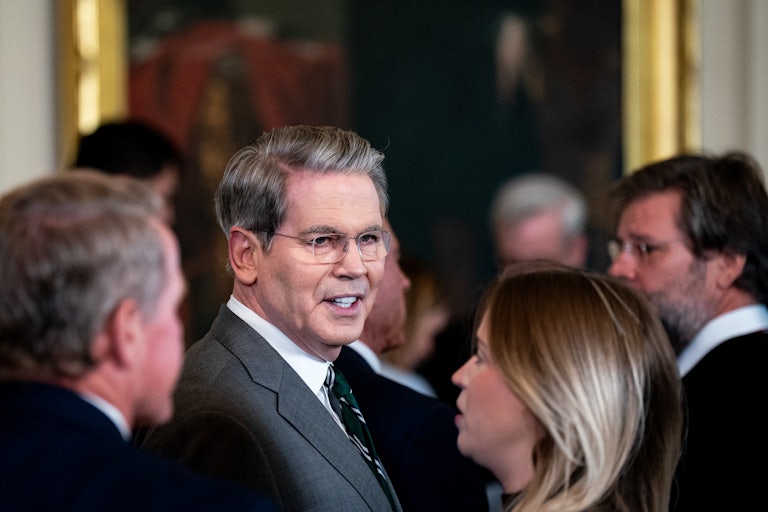 Treasury Secretary Scott Bessent speaks while standing in a crowd at the White House