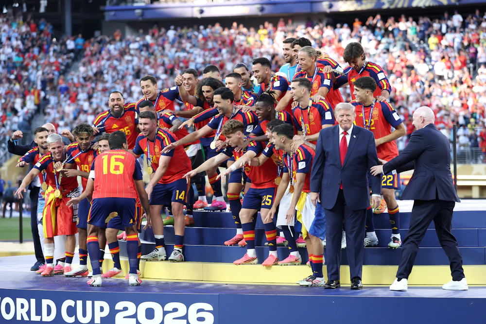 Spain celebrates winning the World Cup as FIFA President Gianni Infantino tries to coax President Trump off the stage.