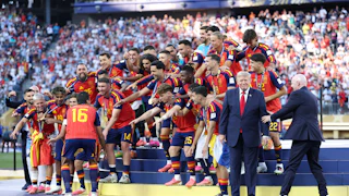 Spain celebrates winning the World Cup as FIFA President Gianni Infantino tries to coax President Trump off the stage.