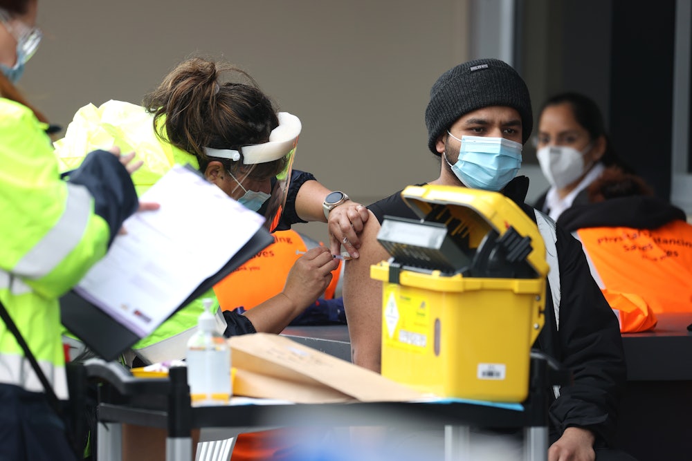 A health worker injects a Covid vaccine into a patient's arm.