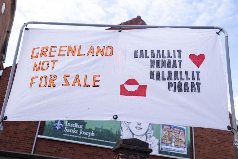 A sign says, "Greenland is not for sale" in English and Greenlandic