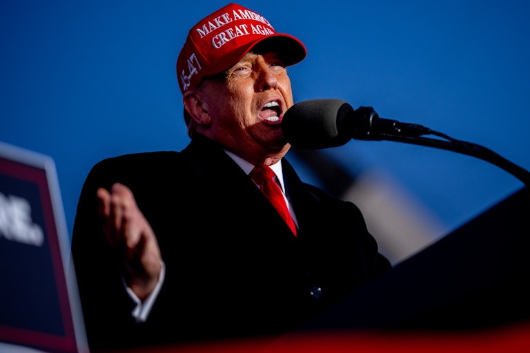 Donald Trump gestures as he speaks into a microphone