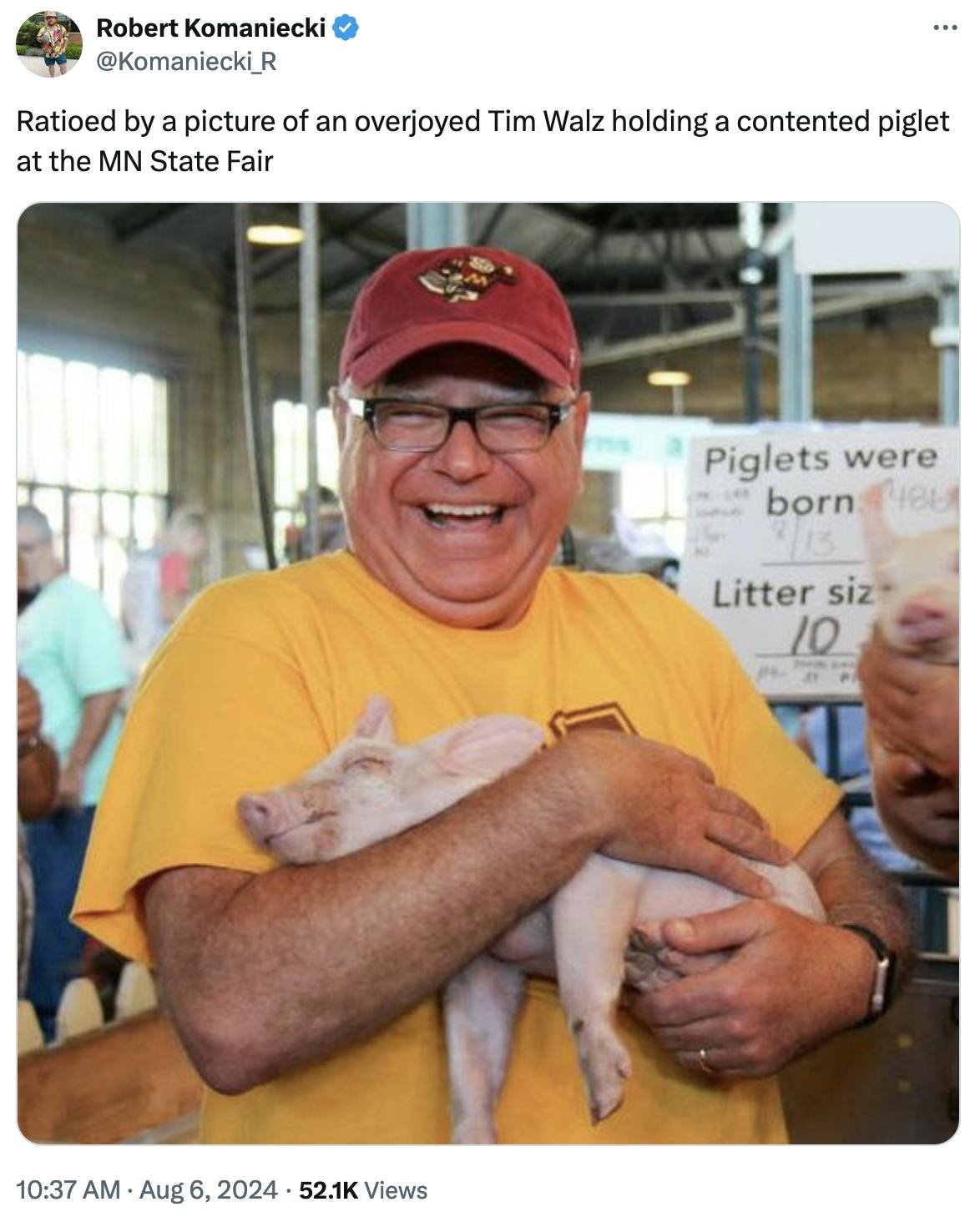 Twitter screenshot Robert Komaniecki @Komaniecki_R: Ratioed by a picture of an overjoyed Tim Walz holding a contented piglet at the MN State Fair (photo of Walz holding a happy piglet)