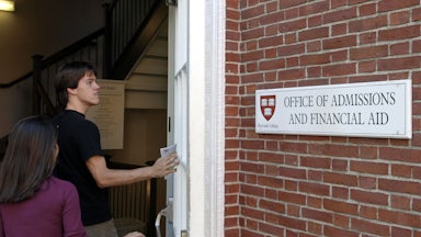 Students enter the Admissions Building on the campus of Harvard University.