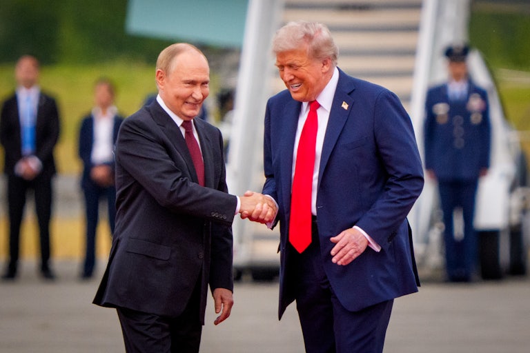 Russian President Vladimir Putin and Donald Trump smile and shake hands on the tarmac at Joint Base Elmendorf-Richardson in Alaska